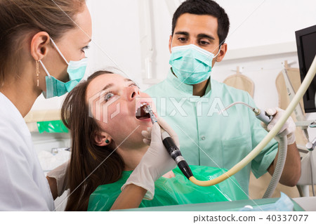 patient checking out her teeth at dentist 40337077
