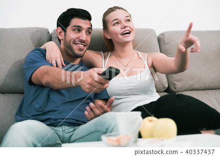 Loving couple on sofa watching TV Loving couple on sofa watching TV 40337437