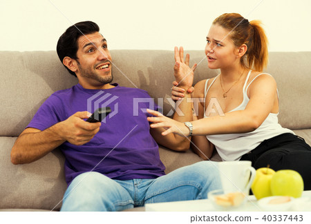Couple on sofa quarreling because of TV remote 40337443