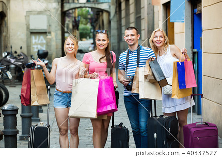 Portrait of three girls and one man standing with shopping bags 40337527