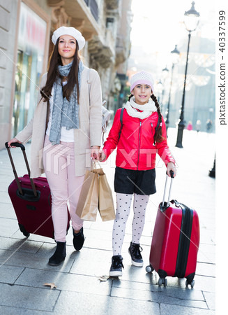 woman with daughter walking with bags 40337599