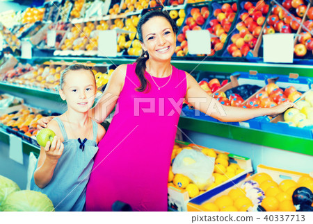 Happy family of woman with daughter buying apples Happy family of woman with daughter buying apples 40337713