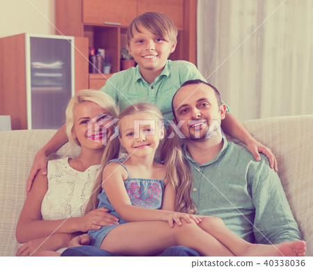 parents with two children posing in home interior parents with two children posing in home interior 40338036