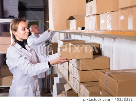 Portrait of different ages couple with carton boxes in warehouse 40338351