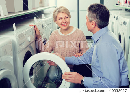 attentive mature couple chooses washing machine for their house in shop of household appliances 40338627
