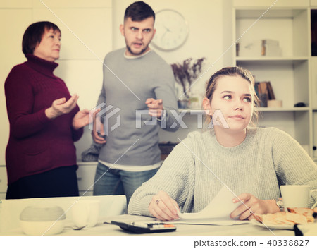 Frustrated woman with papers and discontented family Frustrated woman with papers and discontented family 40338827