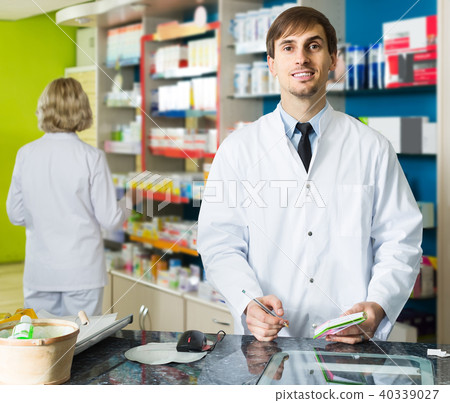 Portrait of male pharmacists working in modern farmacy Portrait of male pharmacists working in modern farmacy 40339027