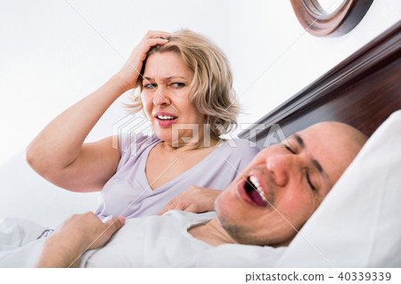 Mature aweary woman disturbed with partner snores Mature aweary woman disturbed with partner snores 40339339