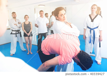 Smiling woman is showing new submission hold to adults Smiling woman is showing new submission hold to adults 40339427