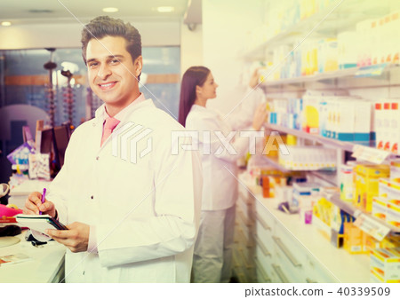 pharmaceutists at reception of drugstore ready to help pharmaceutists at reception of drugstore ready to help 40339509