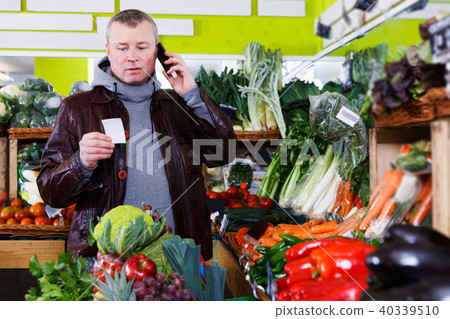 man looking at shopping list, speaking by phone man looking at shopping list, speaking by phone 40339510