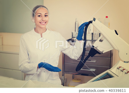 Woman doctor displaying machine for laser hair removal 40339811
