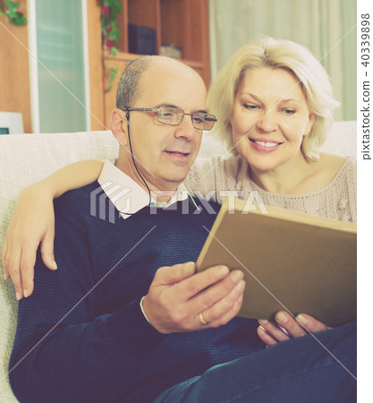 Happy pensioners watching old photoes 40339898