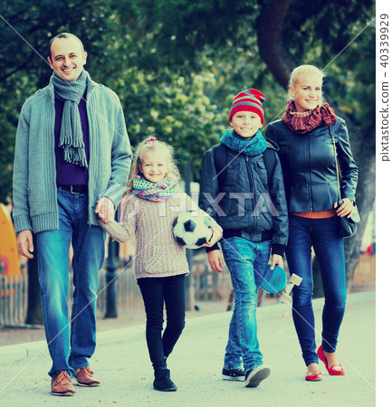 Spouses with children posing in autumn park 40339929