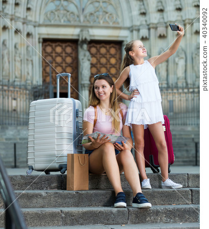 Small girl making selfie with phone, traveling with mother Small girl making selfie with phone, traveling with mother 40340092