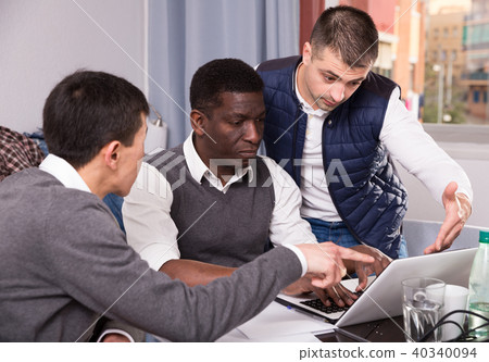 Serious men are talking about project on laptop together Serious men are talking about project on laptop together 40340094