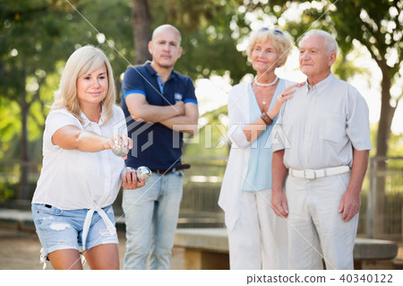 Smiling mature woman and friends playing petanque Smiling mature woman and friends playing petanque 40340122