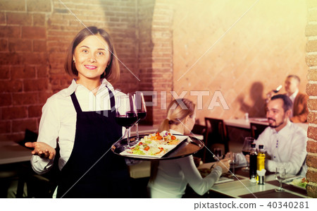 woman waiter demonstrating restaurant to visitors 40340281