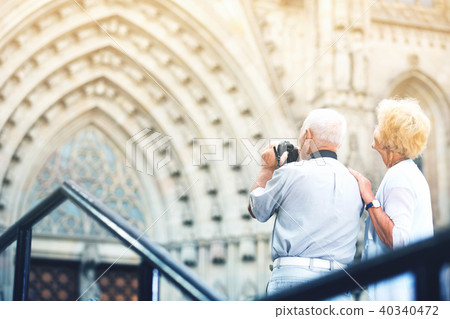 Back view of senior couple travellers making photo with camera Back view of senior couple travellers making photo with camera 40340472
