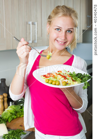 Portrait of cheerful blond girl eating salad Portrait of cheerful blond girl eating salad 40340478