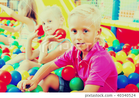 Boy sitting and playing with multicolored plastic balls 40340524