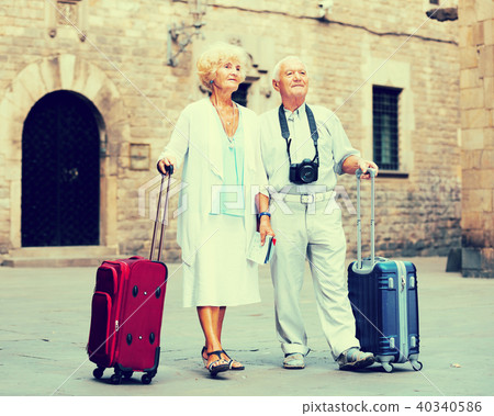 Mature travelers strolling with luggage 40340586