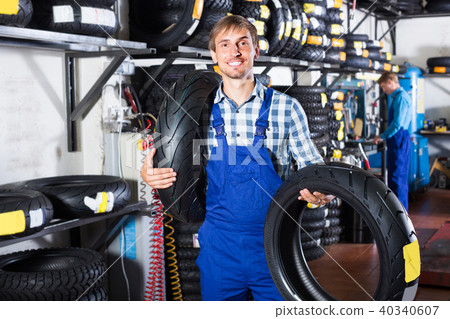 worker holding new tyre 40340607