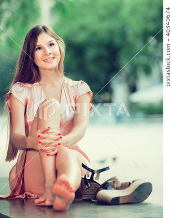young female in rose dress sitting in city young female in rose dress sitting in city 40340674