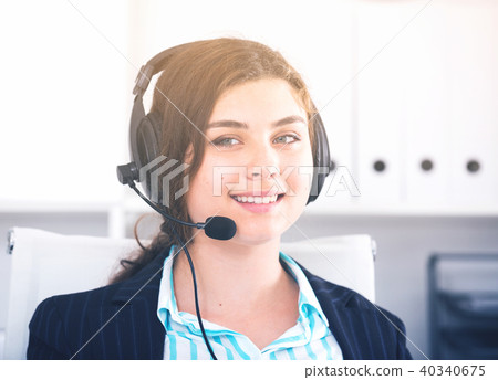 Young trainee dispatcher is working at a computer and talking headset Young trainee dispatcher is working at a computer and talking headset 40340675