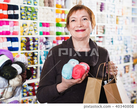 Woman holding shopping bags and accessories for knitting and embroidery 40340808