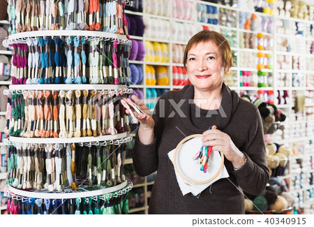 Client woman is buying colorful mouline threads 40340915