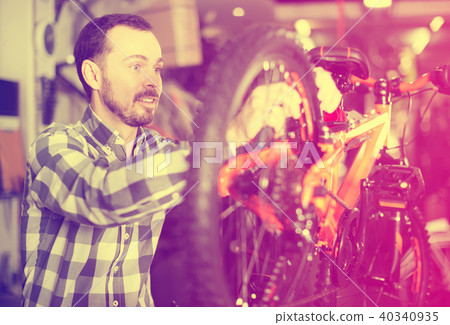 Worker adjusts the bicycle wheel 40340935