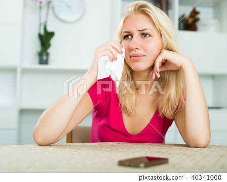crying girl waiting for call at home . crying girl waiting for call at home . 40341000
