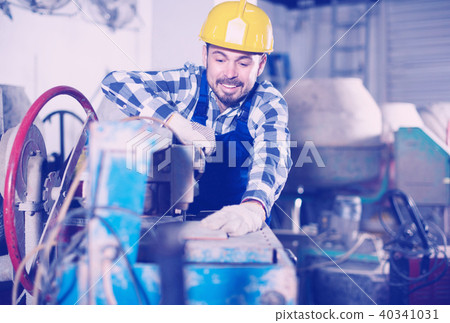 Adult guy is using disk saw to cut tile 40341031