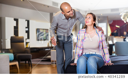 Couple choosing furniture for apartment and trying bed 40341289