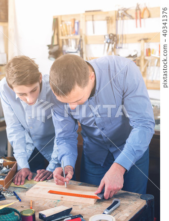 adult father teaching son сarpentry in the garage adult father teaching son сarpentry in the garage 40341376
