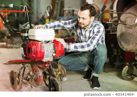 Smiling working man practicing his skills with plough Smiling working man practicing his skills with plough 40341464