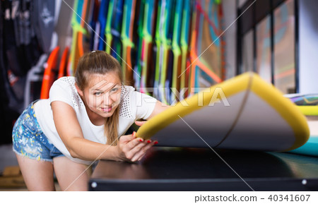 Woman is choosing colorful surfboard in store on the beach. Woman is choosing colorful surfboard in store on the beach. 40341607