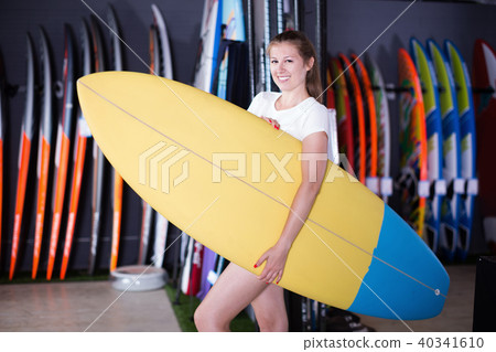 Sport girl surfer holding new surfboard in nautical store Sport girl surfer holding new surfboard in nautical store 40341610