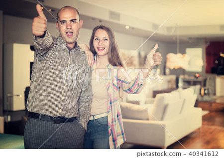 Portrait of man and woman with thumbs up in furniture salon 40341612