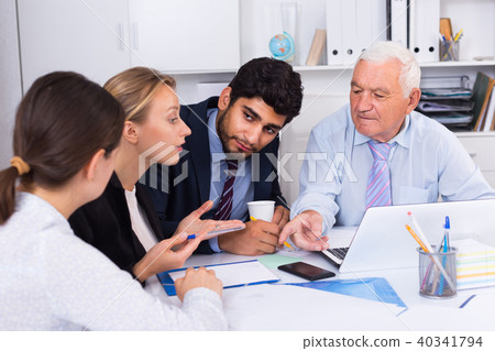Employees are writing financial reports and discussing with mature boss 40341794