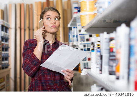 Perplexed female is looking paint by phone Perplexed female is looking paint by phone 40341810