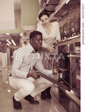 Couple chooses kitchen oven in household appliances store 40341927