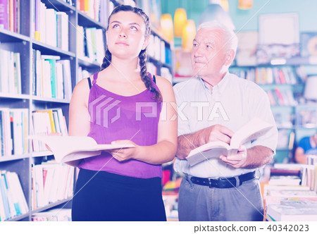Grandfather with granddaughter are reading books Grandfather with granddaughter are reading books 40342023