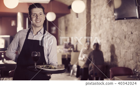 waiter with serving tray welcoming to restaurant waiter with serving tray welcoming to restaurant 40342024