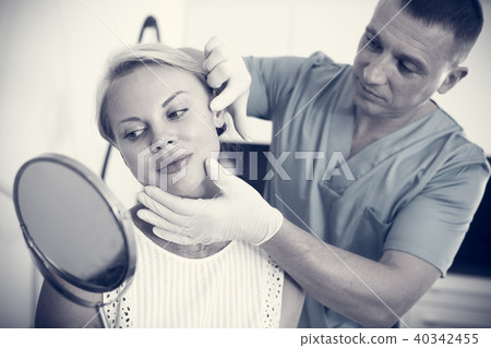 Doctor is examining woman patient behind mirror before the procedure Doctor is examining woman patient behind mirror before the procedure 40342455