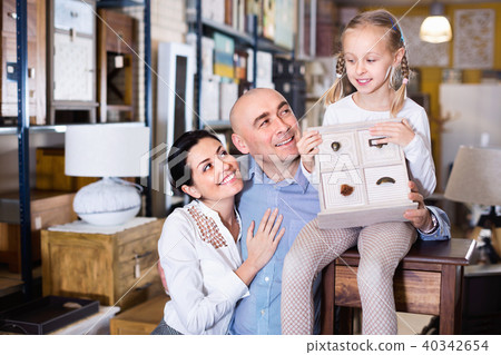Family is holding new curbstone that their choosing for bedroom in the furniture store. Family is holding new curbstone that their choosing for bedroom in the furniture store. 40342654