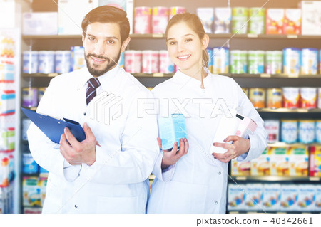 pharmacist and expert standing near shelves with medicines pharmacist and expert standing near shelves with medicines 40342661