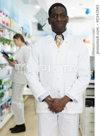 male pharmacist standing in pharmacy male pharmacist standing in pharmacy 40342665