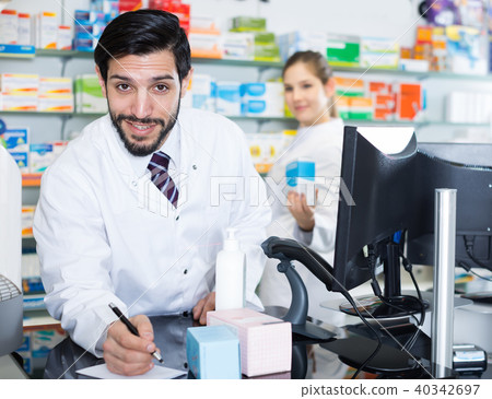 Male is stocktaking medicines with computer Male is stocktaking medicines with computer 40342697
